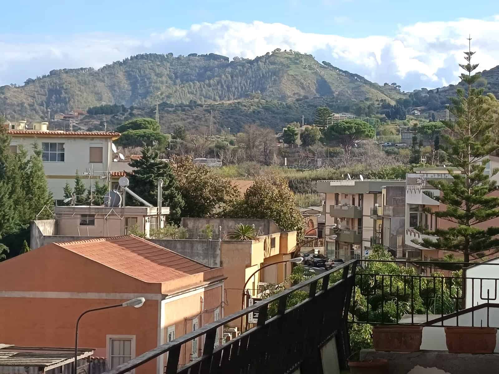 Vista panoramica sulle case di monte di Napoli, con un paesaggio naturale e urbano, circondato da colline verdi e cielo azzurro, ideale per chi cerca immobili con vista mare e natura.