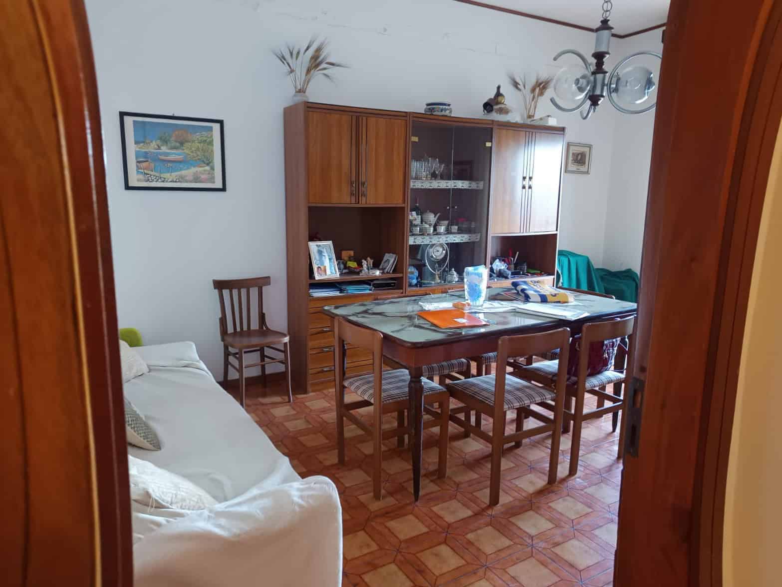 1. Mobili stile classico in soggiorno con tavolo da pranzo, armadi in legno e divano bianco, ambiente accogliente e luminoso.