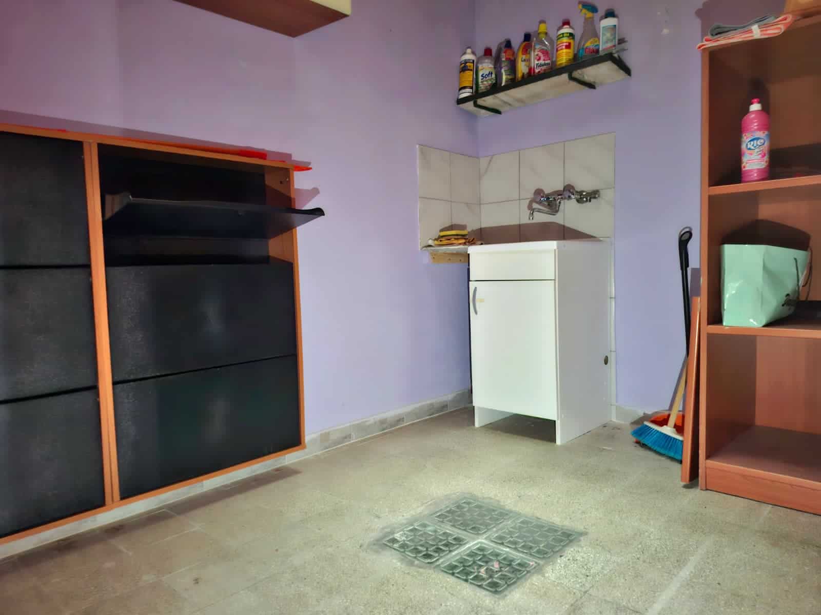 Spazio di servizio con lavello, scaffali e mobili in legno, ideale per arredo di case e appartamenti, con dettagli di ristrutturazione e funzionalità, ottimale per soluzioni abitative.
