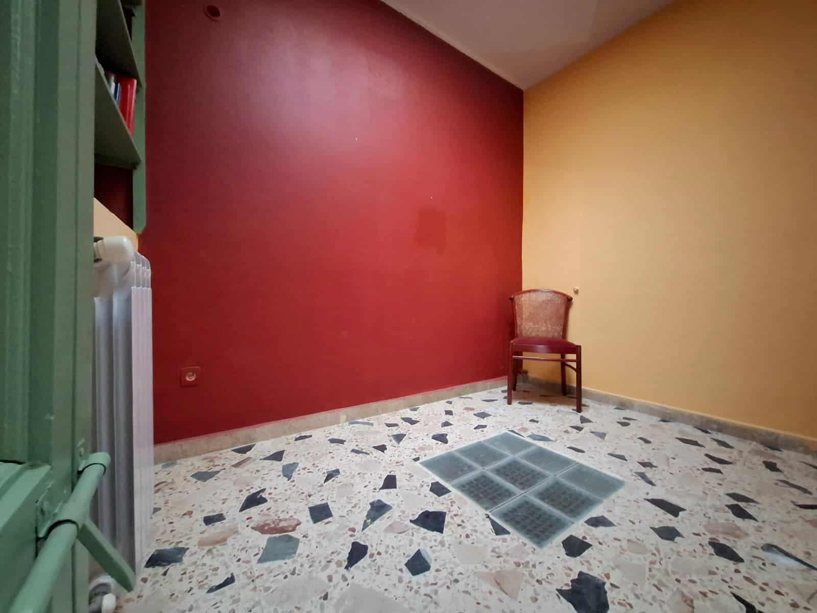 Perfetto esempio di camera ristrutturata con pareti colorate, pavimento in terrazzo, sedia in stile classico e ventilazione forzata, perfetta per ambienti residenziali o commerciali di design.