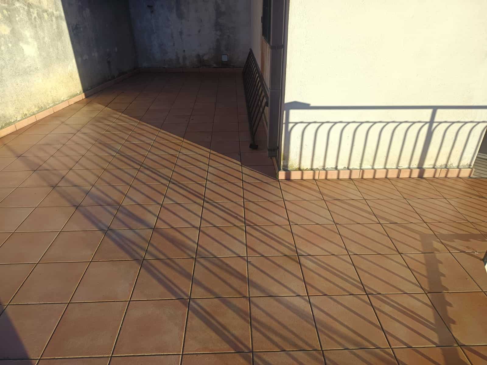 Terrazza con piastrelle in graniglia e ringhiera in ferro, ideale per spazi esterni di case e appartamenti.