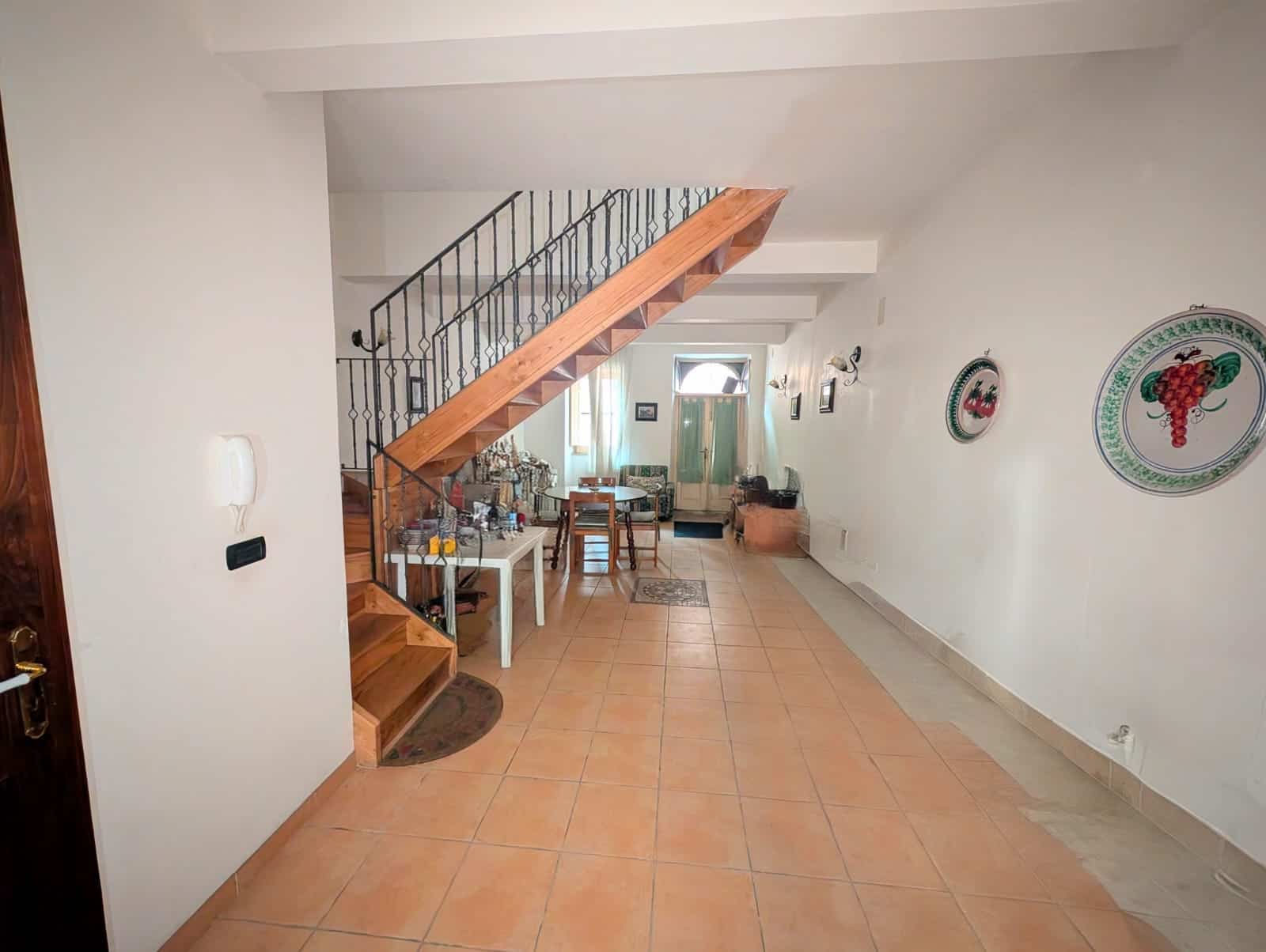 1. Interno di casa con scala in legno e pareti bianche, ambiente luminoso e accogliente, perfetto per appartamenti in stile tradizionale italiano.