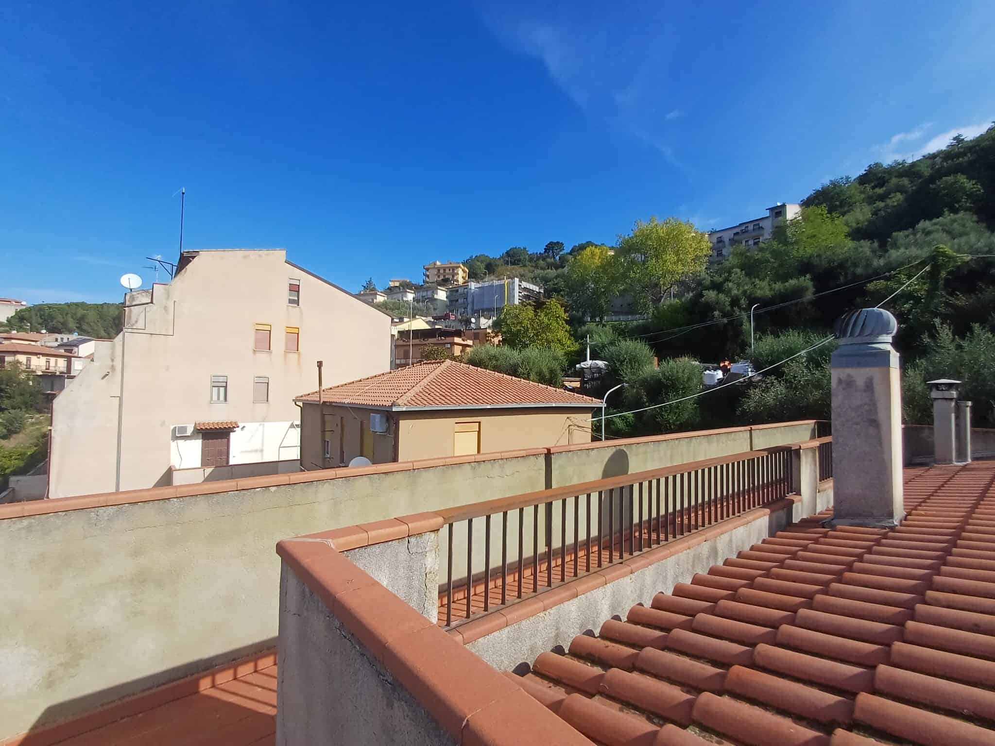 Relaxing view di una zona residenziale con colline verdi e cielo azzurro, perfetta per promuovere immobili con terrazze e spazi esterni in contesti panoramici.