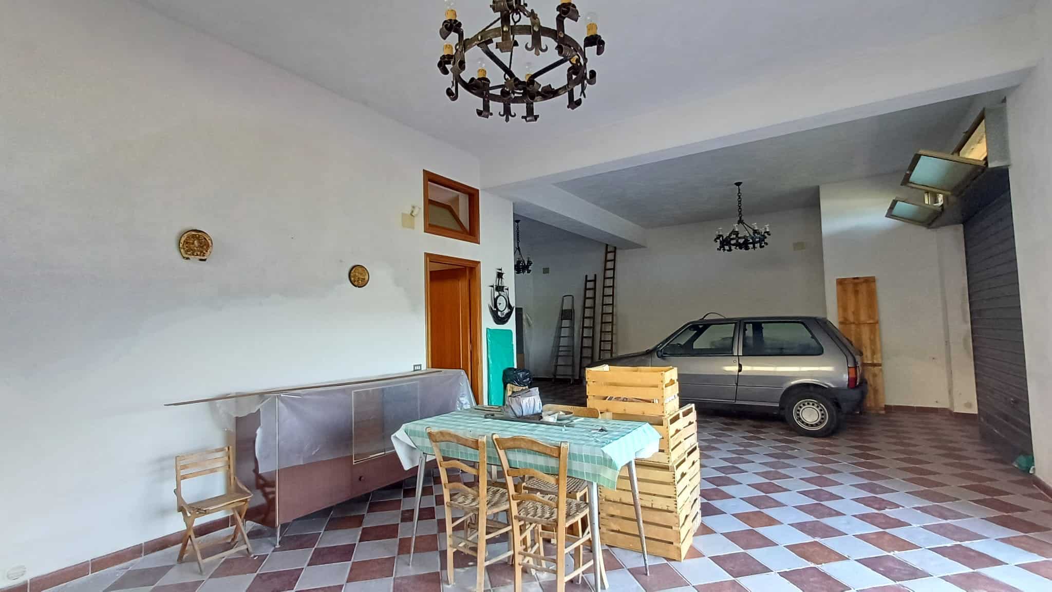 Auto rimessa con auto, spazio garage attrezzato; soluzione immobiliare NextCasa, ambiente spazioso e funzionale.
