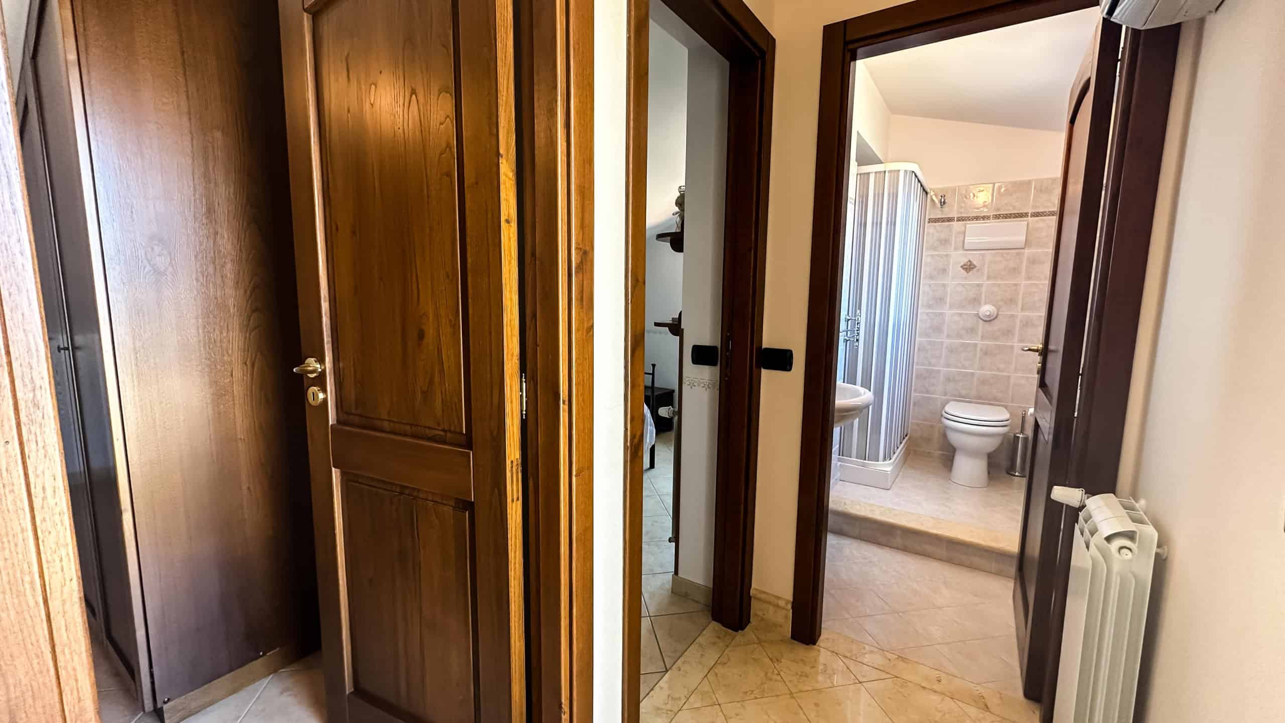 Armadietto in legno nel corridoio che conduce al bagno e alle altre stanze della casa.