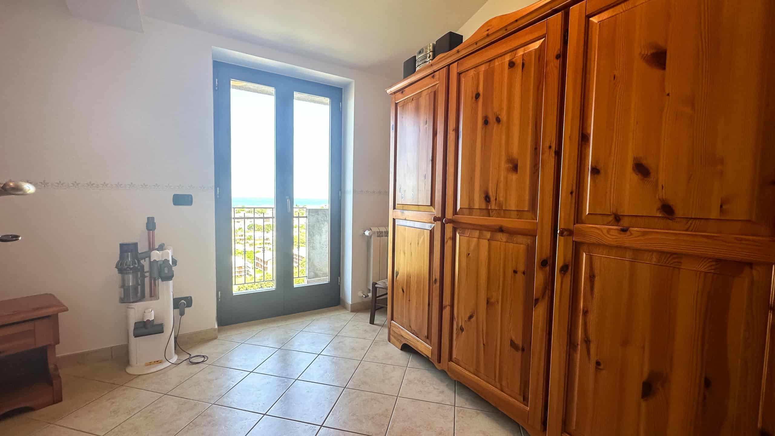 Armadio in legno massello, camera da letto dotata di spazio ripostiglio, vista panoramica mare, arredamento rustico, mobilio di qualità, casa vacanze sul mare, NextCasa, immobile di charme in affitto.
