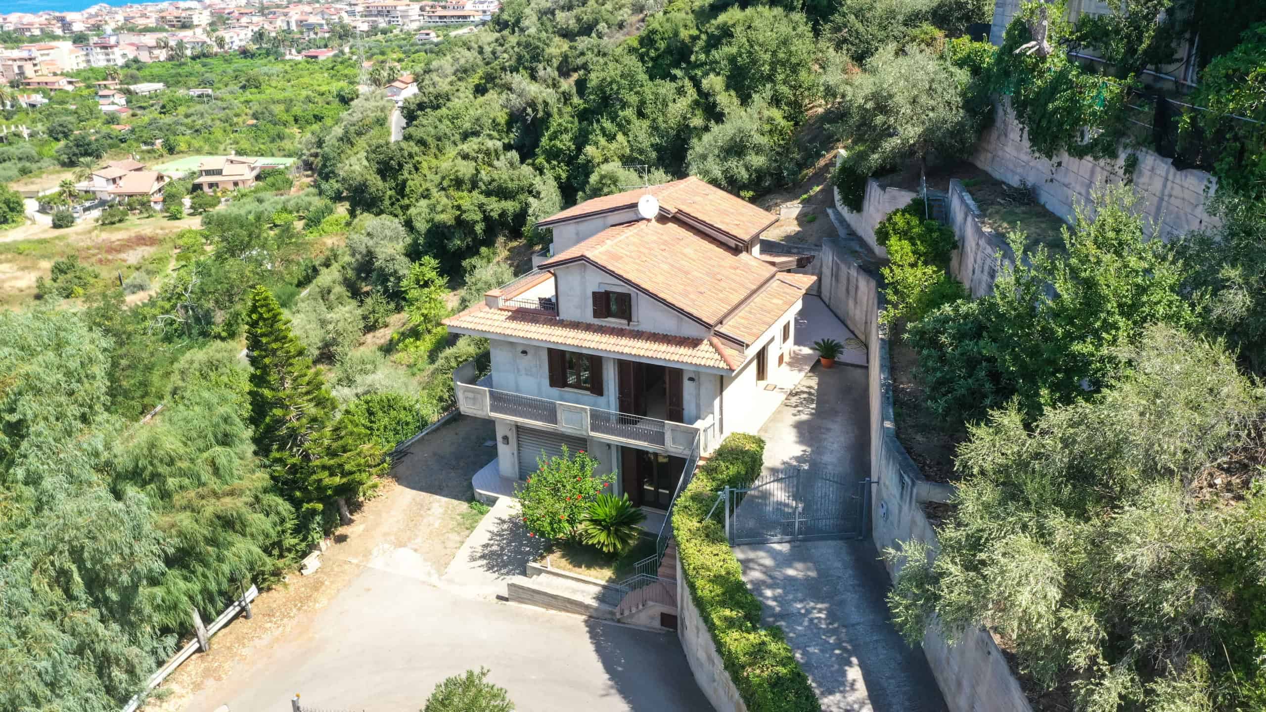 Villa immersa nel verde con vista panoramica, giardino curato e architettura moderna in zona residenziale esclusiva. Casa indipendente con ampie finestre e spazi esterni privati.