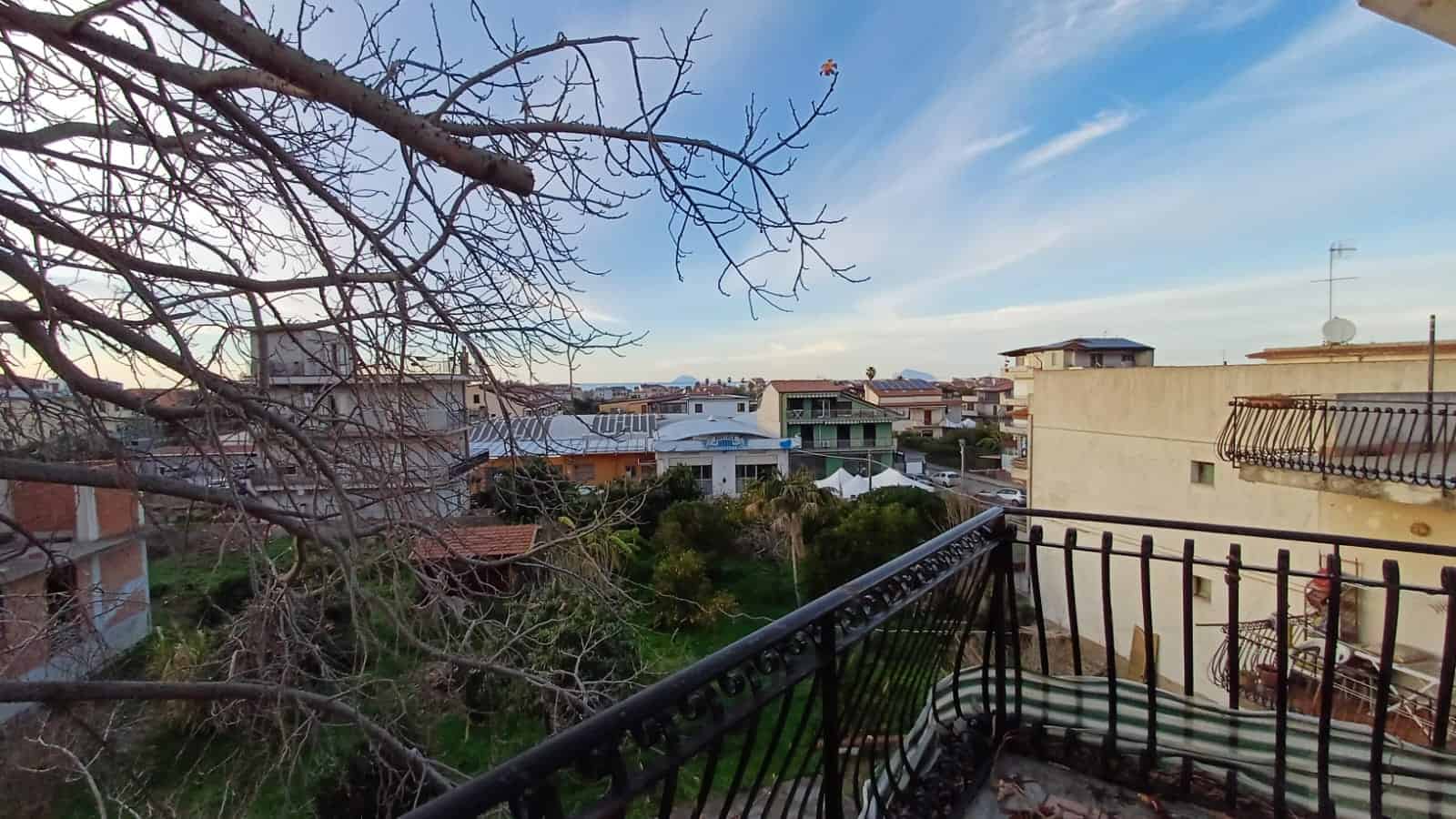 VISTA DALLA BALCONATA SUL QUARTIERE RESIDENZIALE NELLE VILLE DI NEXTCASA, CON PANORAMA SU TETTI, GIARDINI E Cielo A LUGLIO.