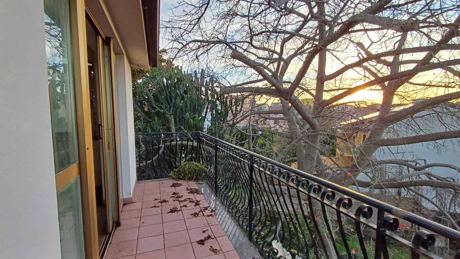 Balcone con vista su alberi e natura, ideale per relax e momenti all'aperto, con serramenti in alluminio e ringhiera in ferro battuto, in un ambiente tranquillo e luminoso.