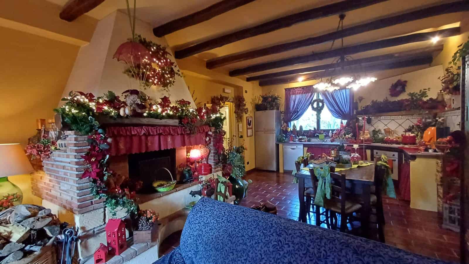 Camino decorato natalizio, soggiorno accogliente con camino, atmosfera festiva, decorazioni di Natale, luci calde, ambiente caldo e familiare, ideale per le festività invernali.