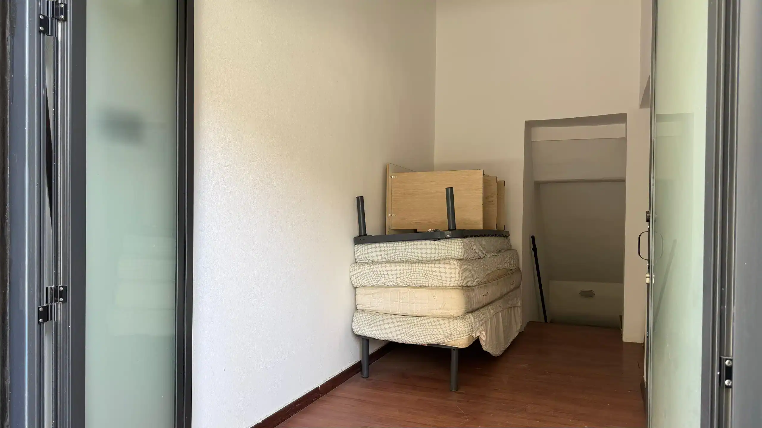 Divano letto con letto a scomparsa in una stanza moderna, ideale per appartamenti condivisi e soluzioni abitative funzionali.