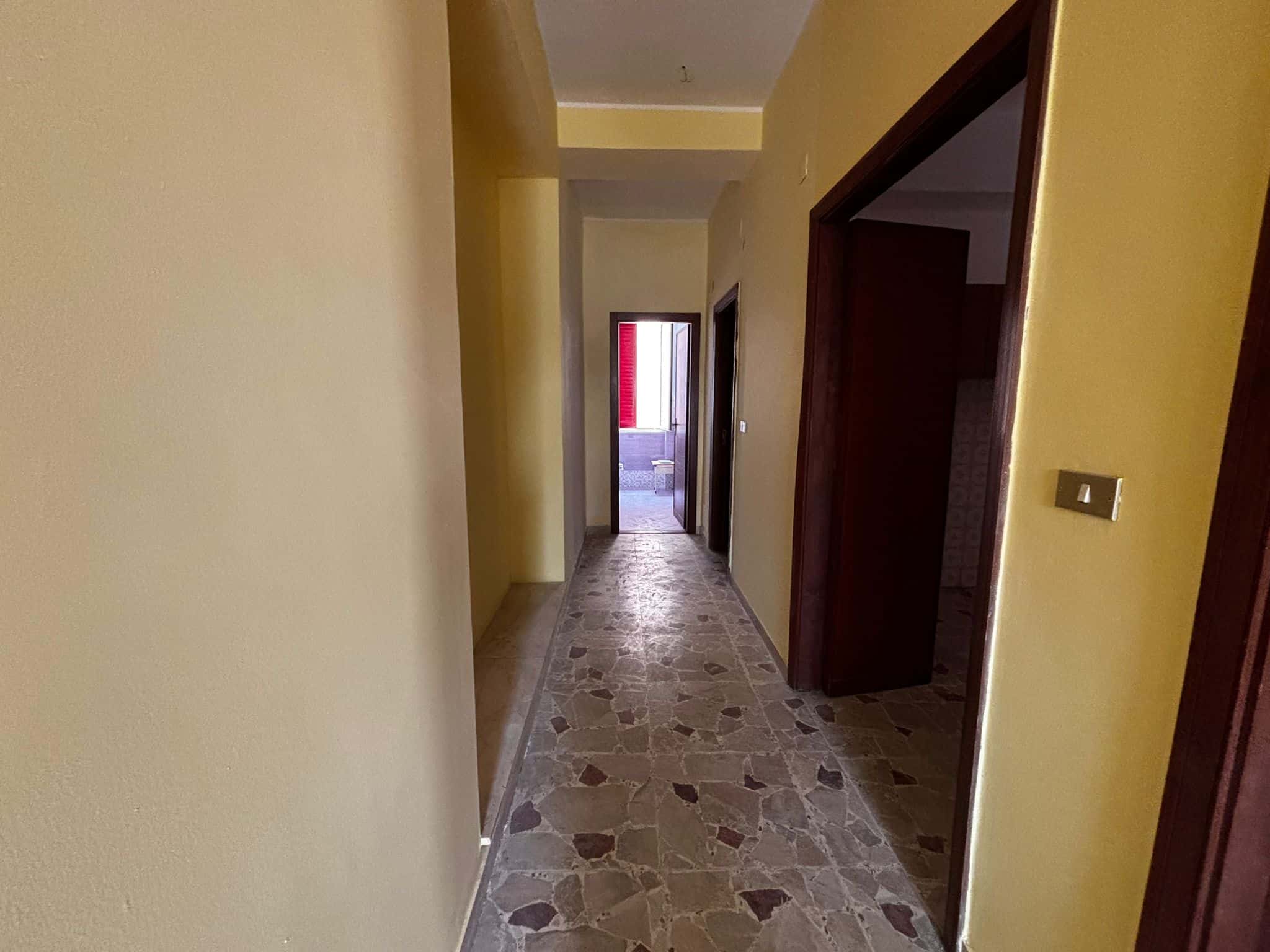 Elegante corridoio di casa con pareti color pastello e pavimento in marmo, ideale per interni moderni e accoglienti, perfetto per valorizzare la tua proprietà con NextCasa.