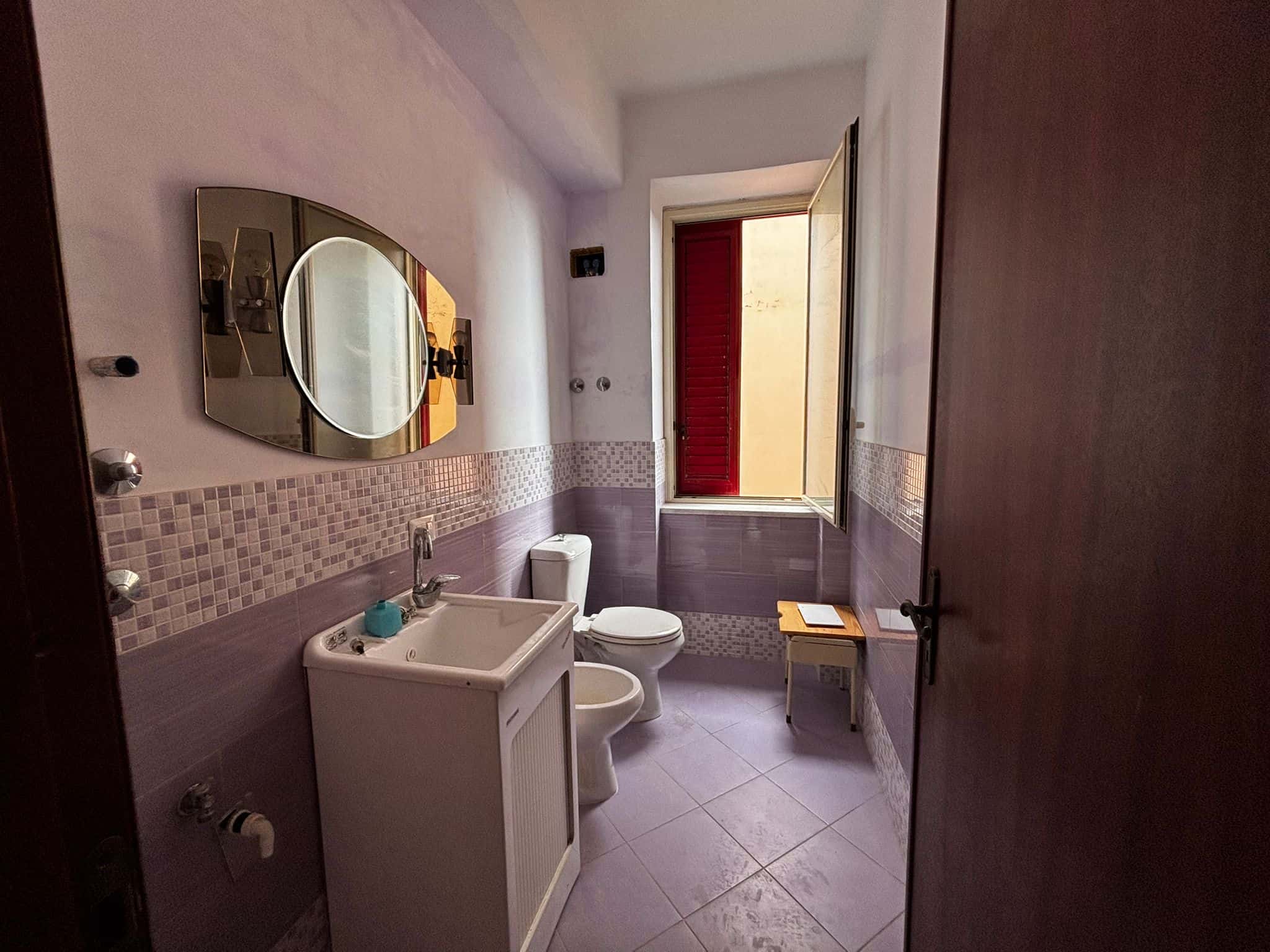 Lavabo e bagno con finestra, stile semplice e funzionale, dettagli precisi, rivestimenti in piastrelle, ambiente luminoso e arieggiato, perfetto per servizi quotidiani in casa o appartamento.