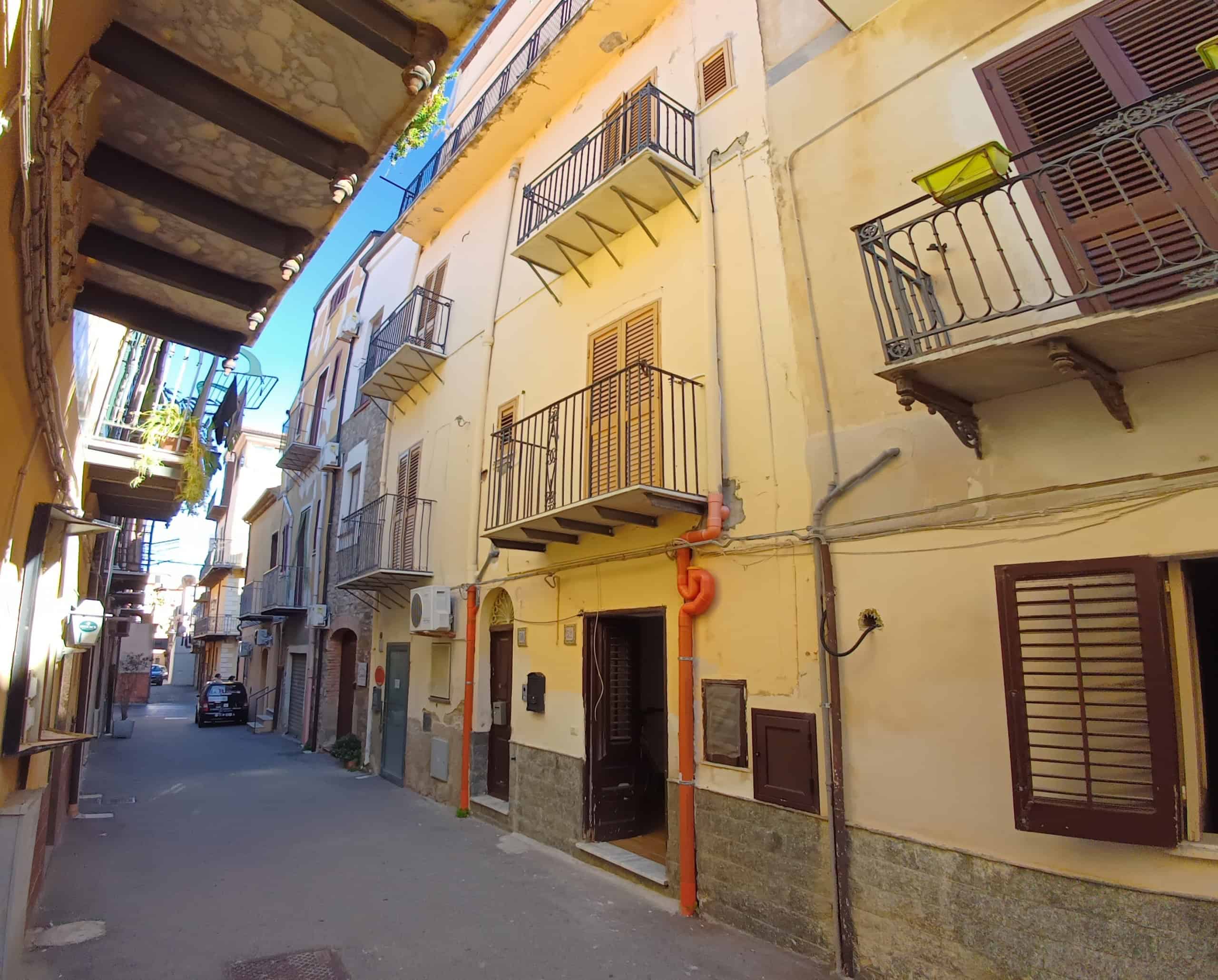 1. Balconi in ferro battuto e facciata di un edificio storico nel centro di Napoli, atmosfera autentica e caratteristica, ideale per immobili di charme.