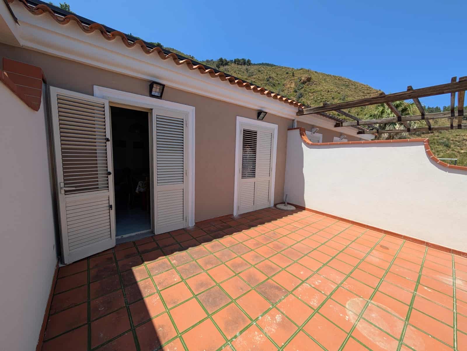 Splendida terrazza con vista montagna, pavimentata in terracotta, ideale per momenti di relax e convivialità all'aperto.