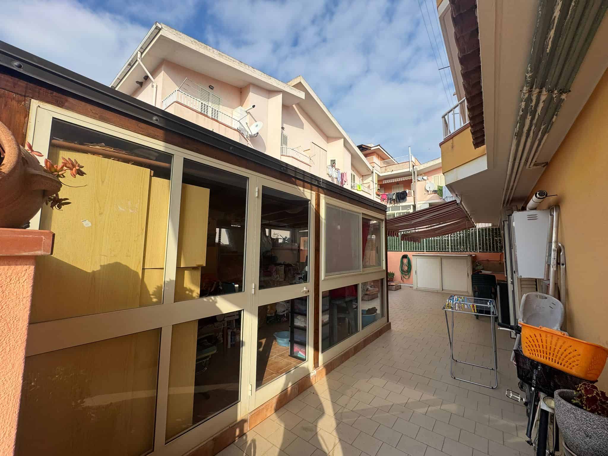 Balcone soleggiato e spazioso con vista sulle case vicine, ideale per relax e attività all'aperto.