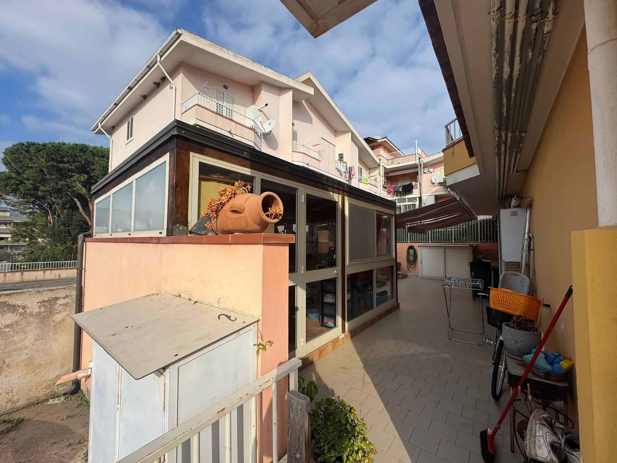 Balcone di casa con spazio esterno, arredi e accessori, vista sugli edifici circostanti, ideale per vivere all'aperto.