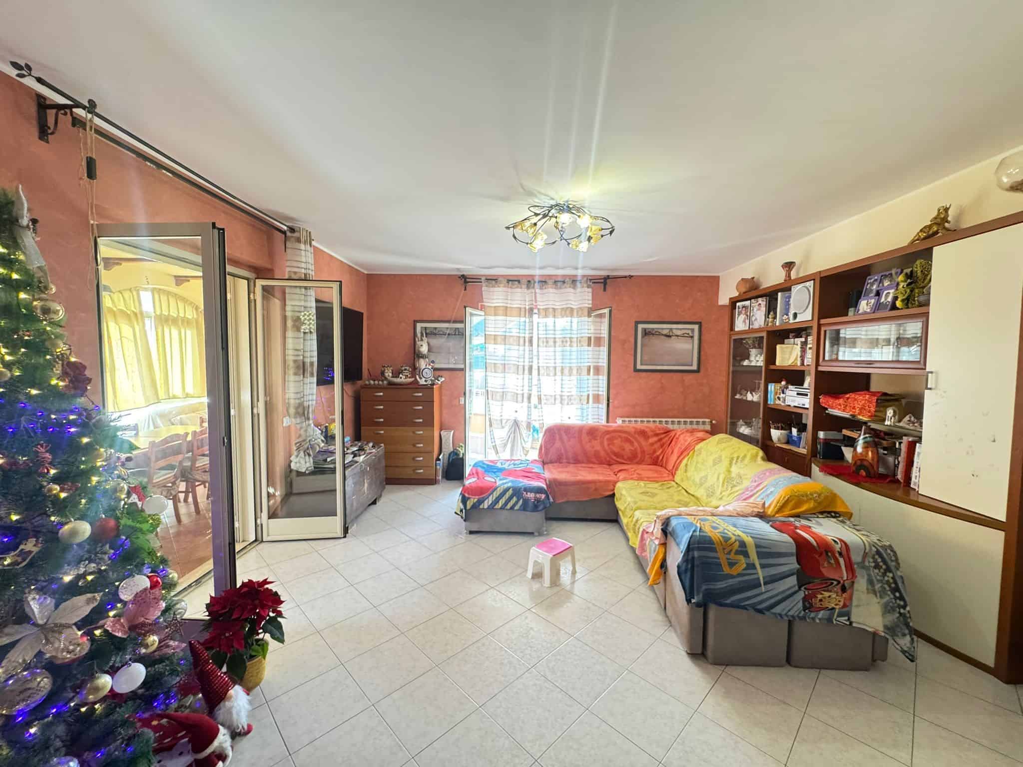 1. Divano angolare colorato in soggiorno con libreria, decorazioni natalizie e accessori di casa, ambiente confortevole e vivace.