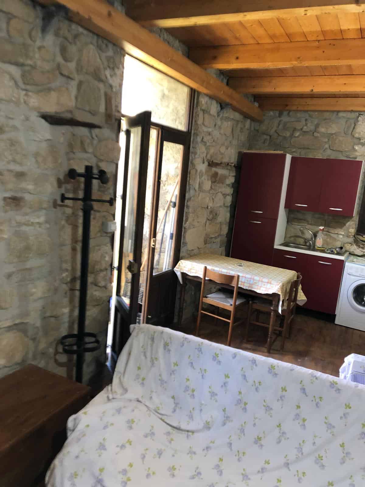 1. Cucina rustica in stile tradizionale con pareti in pietra e soffitto in legno, ideale per case di campagna o residenze caratteristiche.