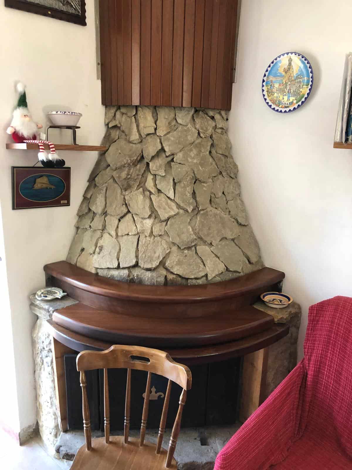 1. Caminetto rustico in pietra con struttura in legno, arredamento tradizionale per ambienti accoglienti.
