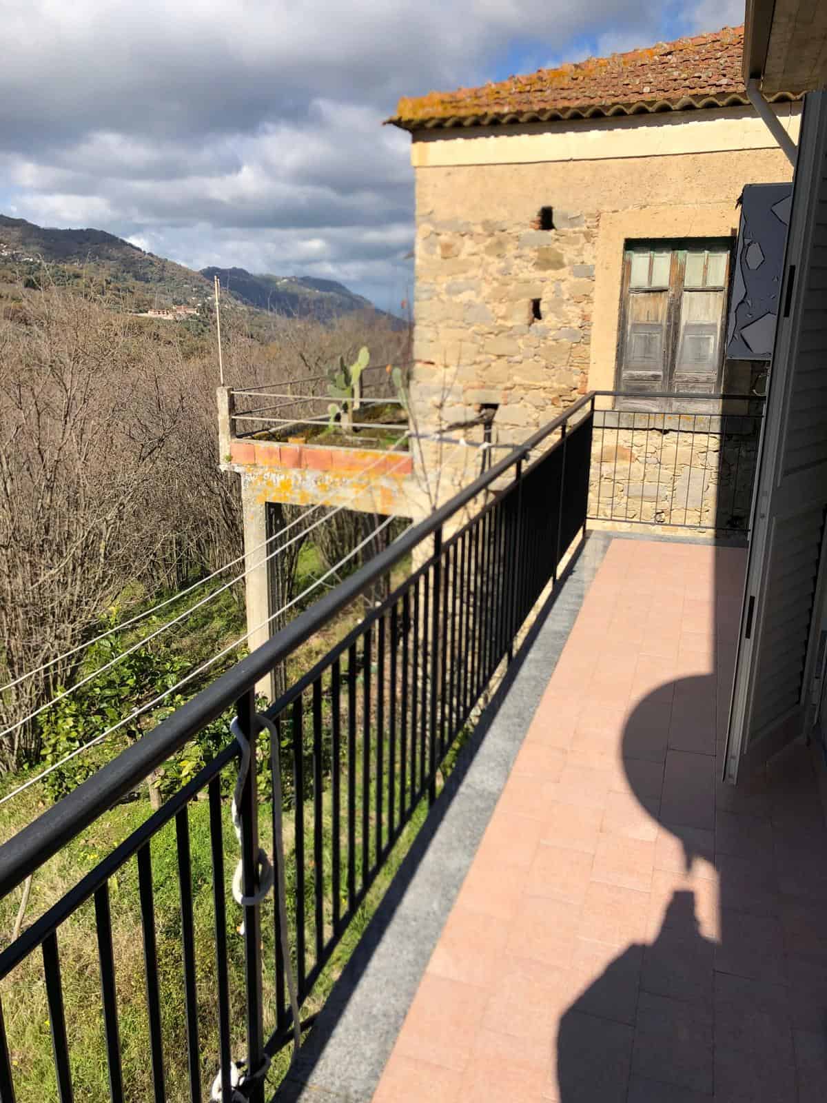 Balcone con vista sul paesaggio naturale e montagne, completa con ringhiera in ferro e piastrelle in ceramica, ideale per godersi l'aria aperta e il panorama.