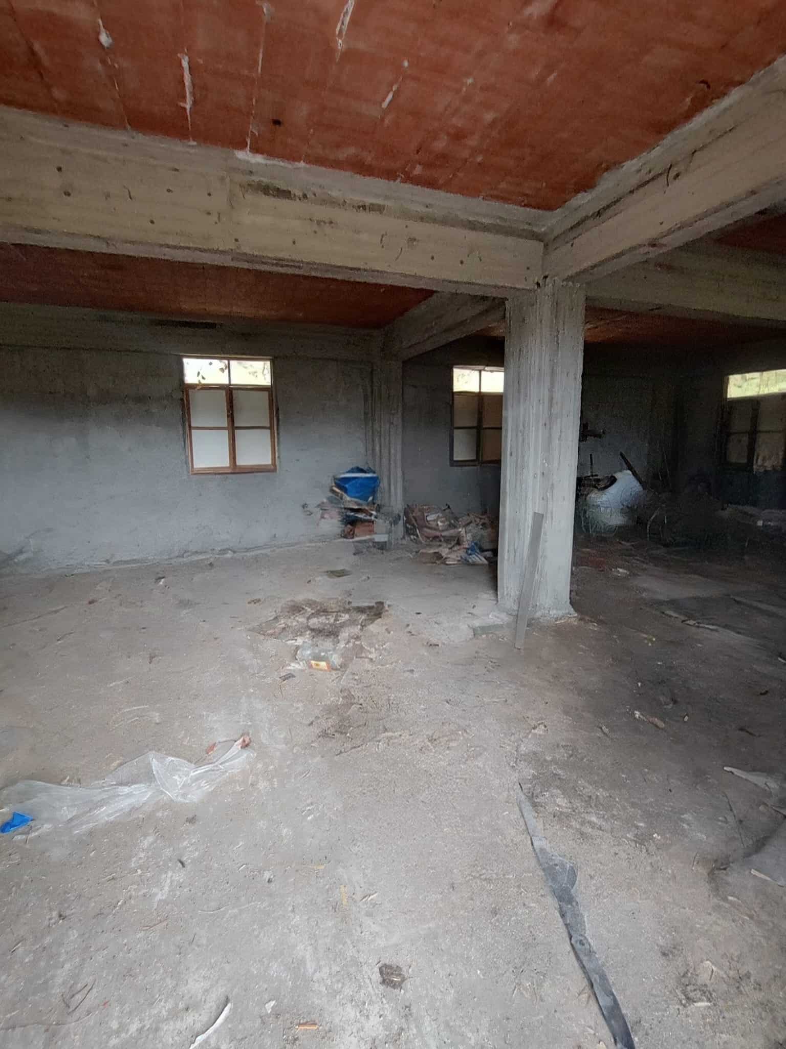 1. Interno di un edificio in costruzione con muri in cemento e botte in legno responsabile lavori di ristrutturazione edilizia.