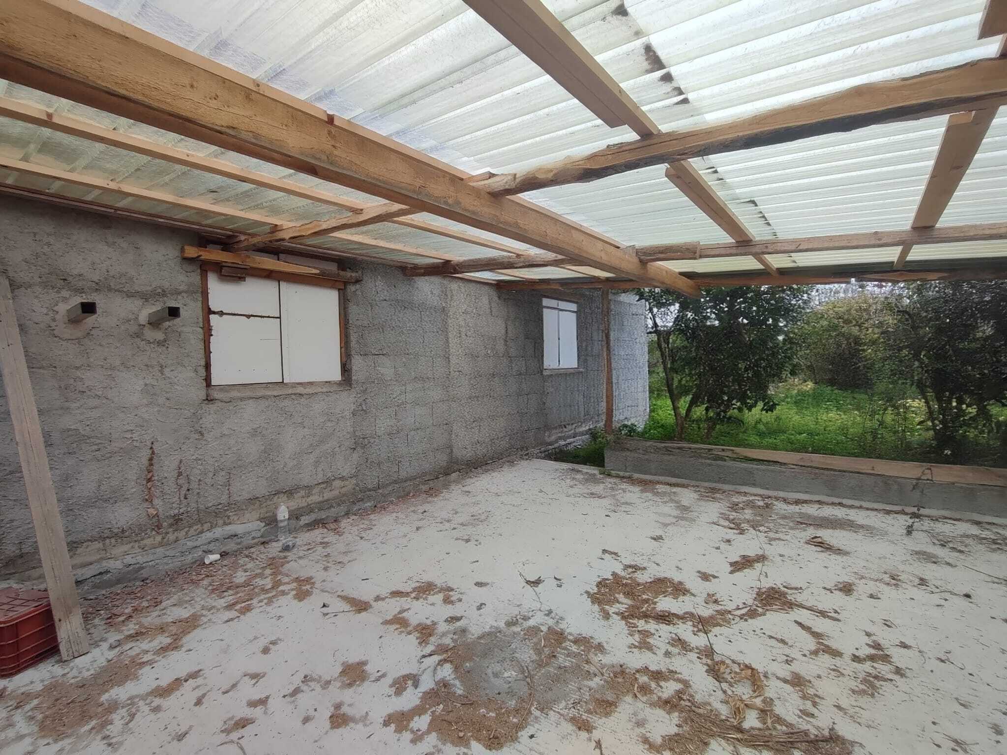 Veranda in costruzione con strutture in legno e copertura in policarbonato trasparente, pronta per il completamento e la trasformazione in uno spazio abitabile all'aperto.