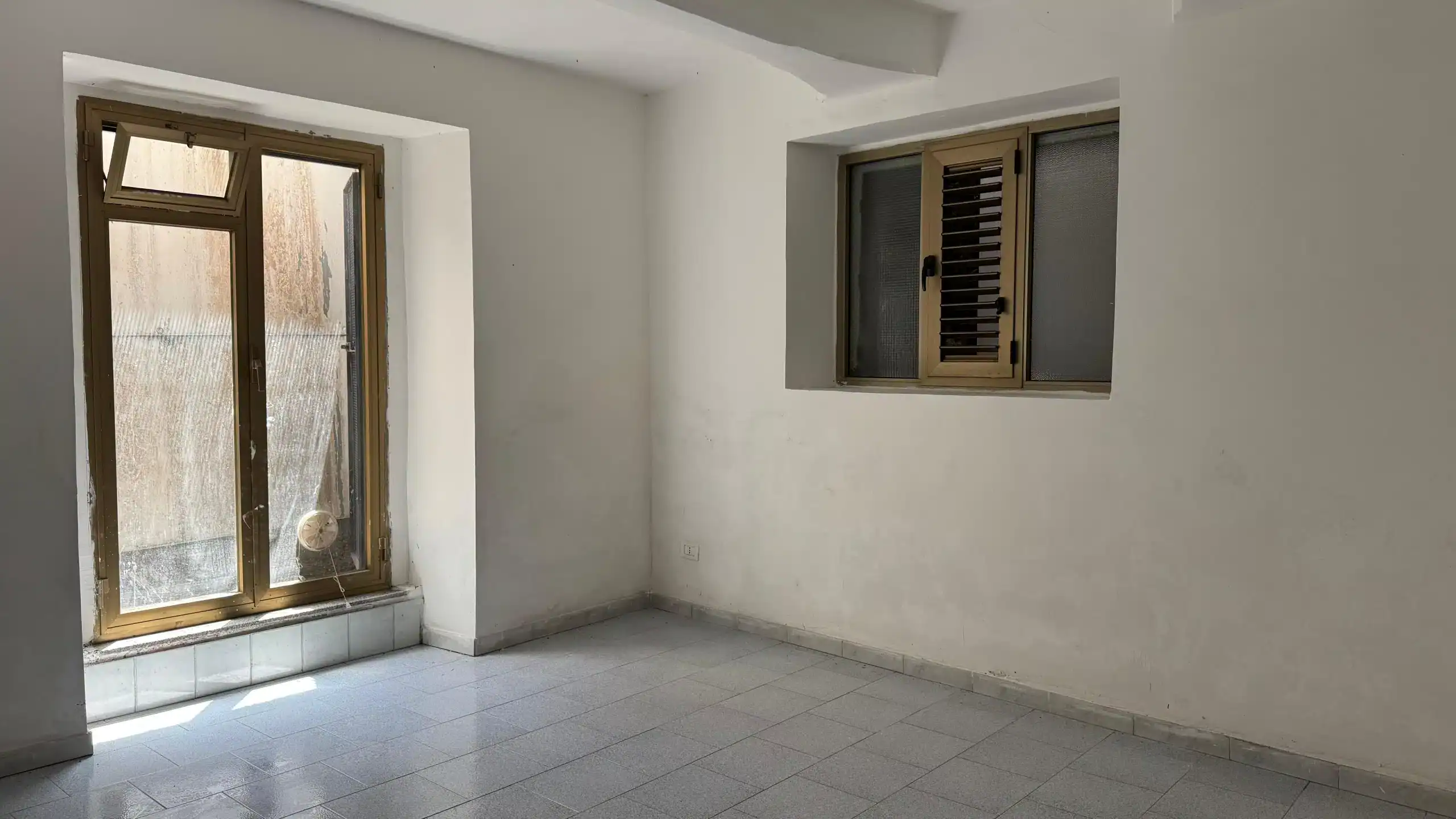 Balcone in un appartamento nuovo con finestre in alluminio, ambiente luminoso e spazioso, pronto per essere arredato, ideale per soluzioni di abitazioni e investimento immobiliare.