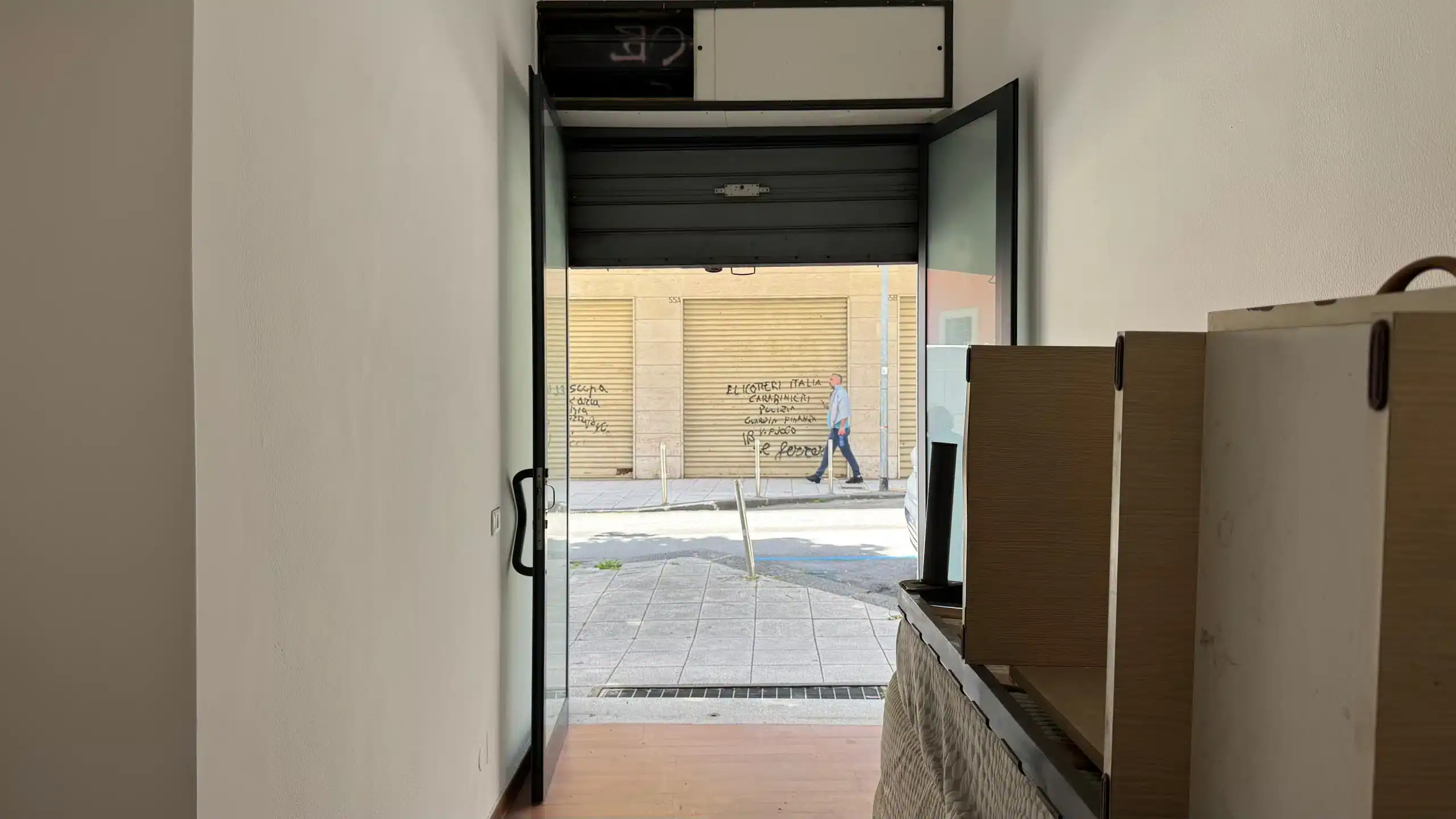 Getto ingresso negozio NextCasa, arredamento moderno e vetrina con vista sulla strada urbana, luce naturale, stile minimalista, atmosfera accogliente e funzionale, ambiente commerciale di alta qualità.