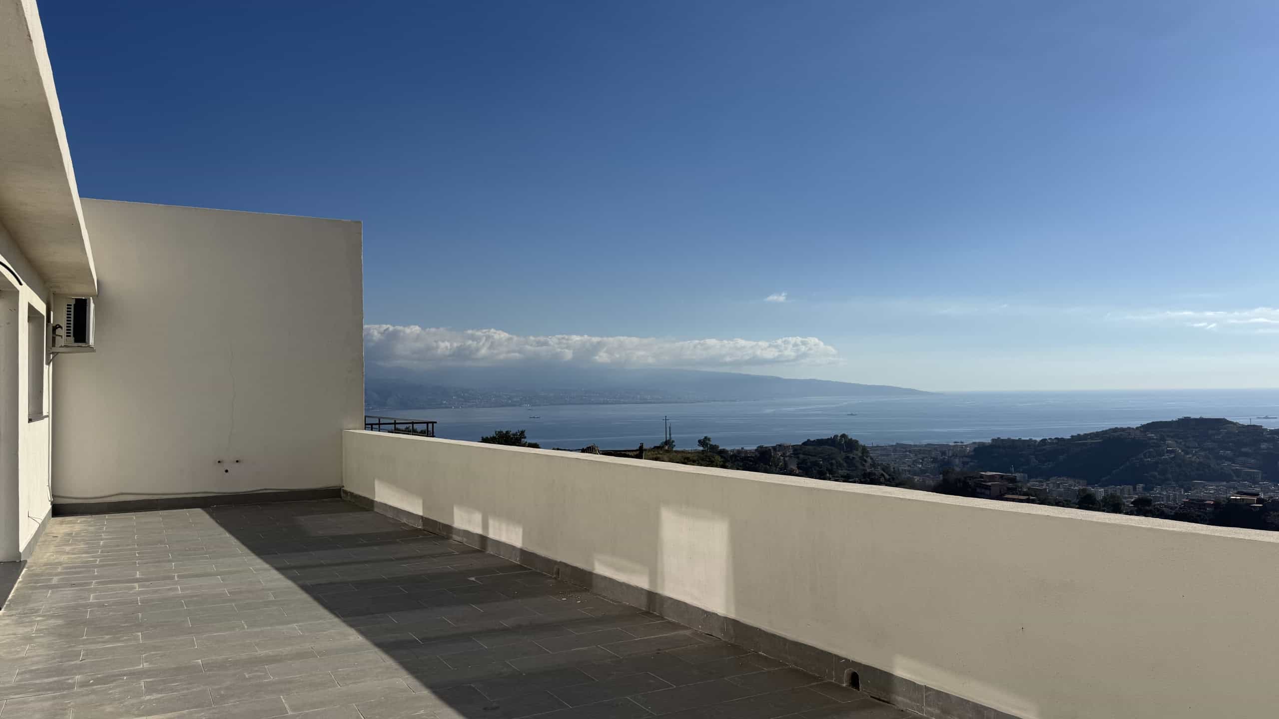 Vasta terrazza con vista mare e panorama sulla costa vista dal tetto di un edificio moderno.