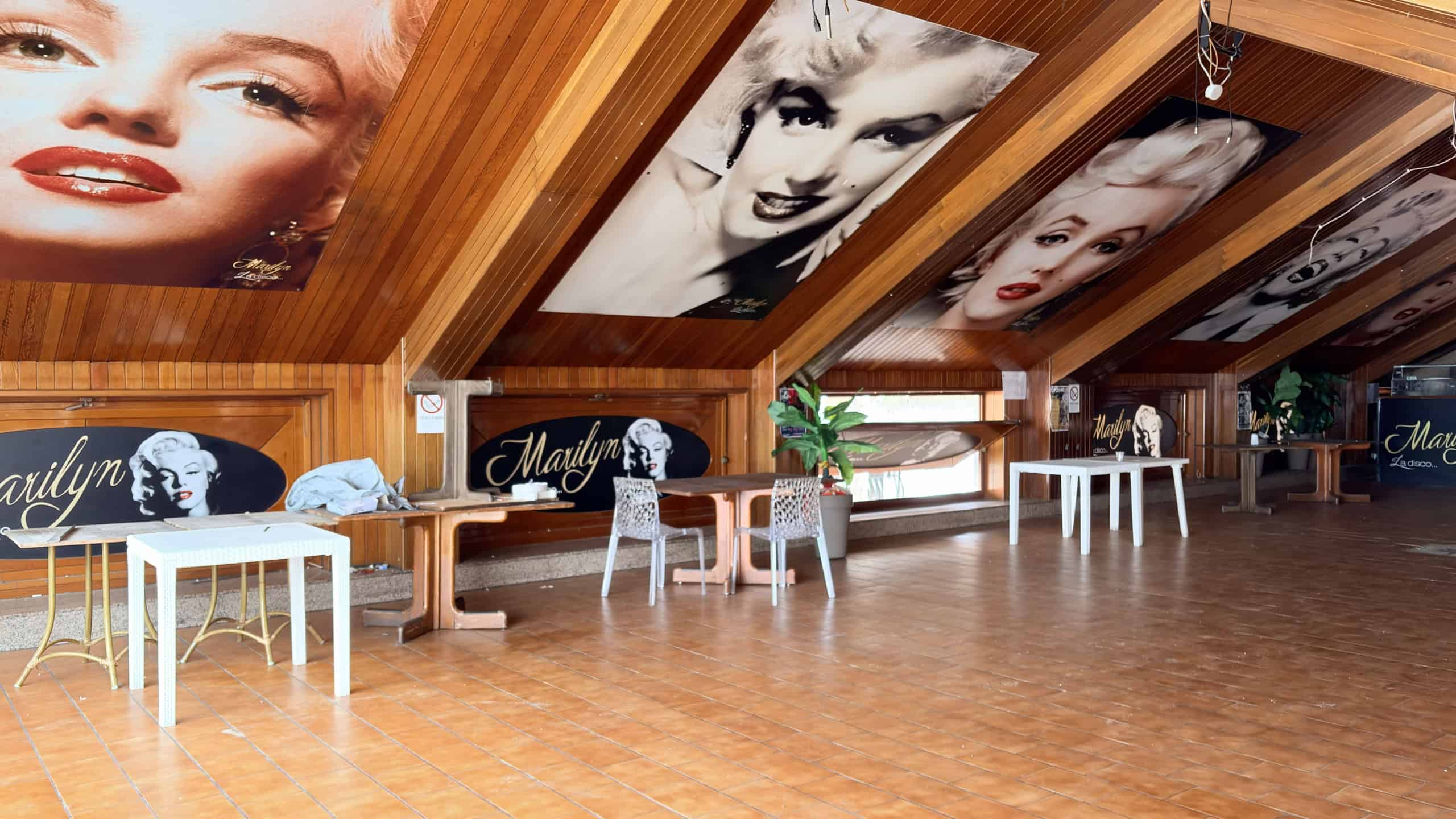 1. Murale con ritratti iconici di Marilyn Monroe e Audrey Hepburn in interni di locali, decorazioni vintage e atmosfera retrò.