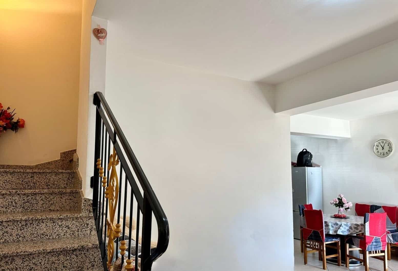 Ampia scala in granito e soggiorno con zona pranzo, interni luminosi, stile moderno, ideale per case in affitto o vendita, con arredi funzionali e dettagli di design.