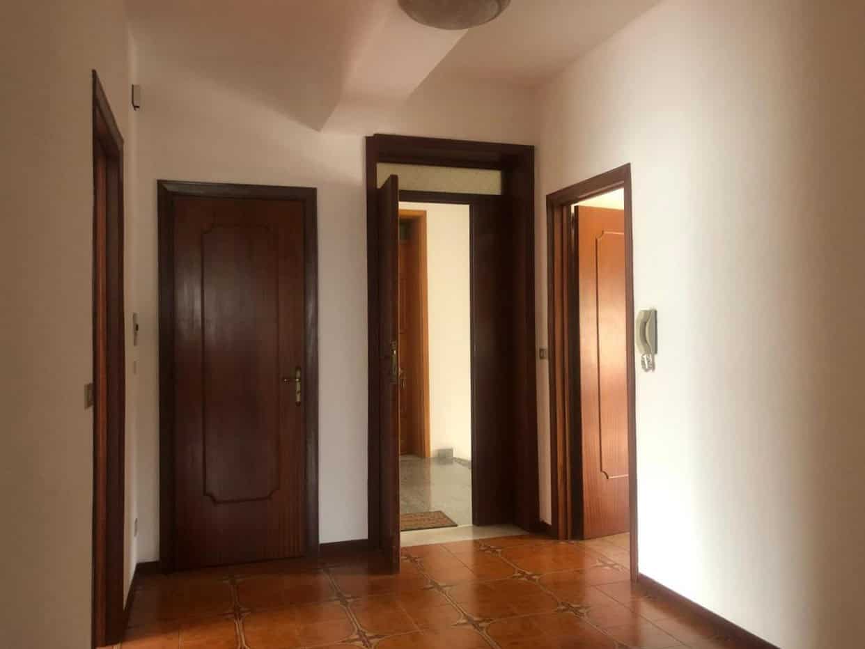 Porta di ingresso in legno massiccio con tre stanze e pavimento in ceramica anni '80, zona centrale e luminosa per l'accesso alle diverse stanze dell'appartamento.