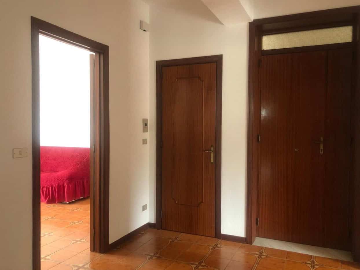 1. Portafinestra e porte in legno in appartamento con pavimento in ceramica.