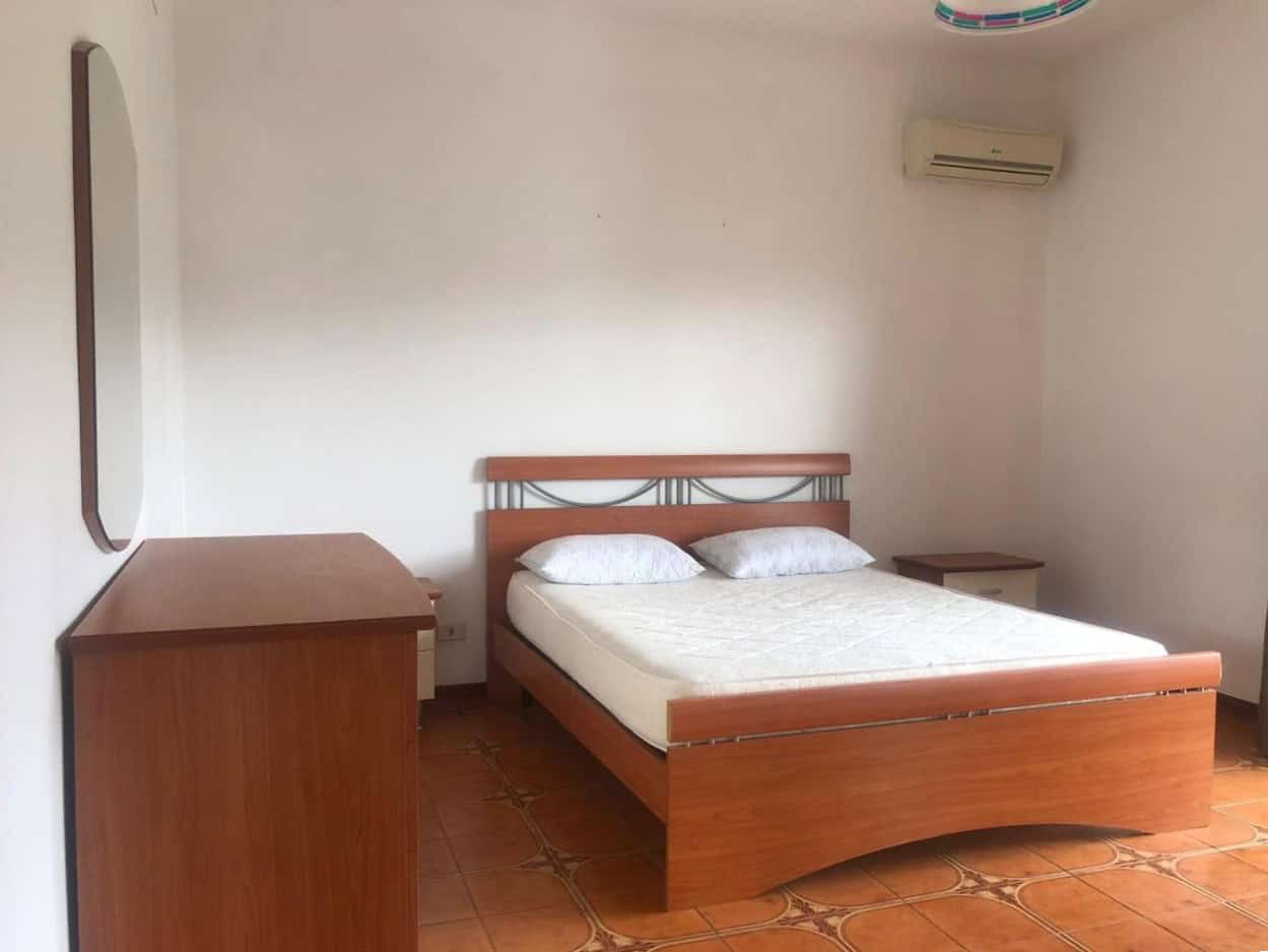 Letto matrimoniale in camera da letto con comodini, arredo semplice e funzionale, ideale per affitti turistici o residenziali, ambiente luminoso e confortevole.
