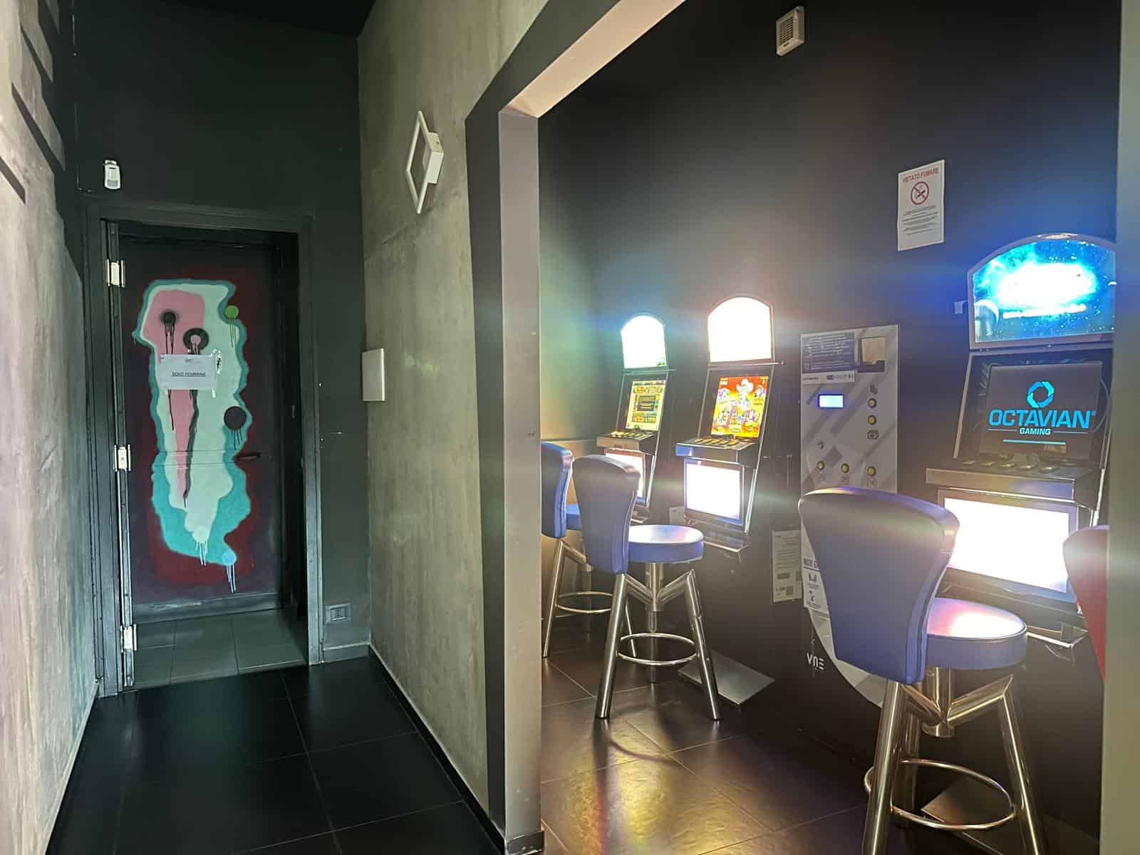 Gioco di slot machine in un casinò con luci luminose e sedili blu in un ambiente moderno e accattivante. Perfetto per chi cerca divertimento e intrattenimento tra giochi di casinò digitali.