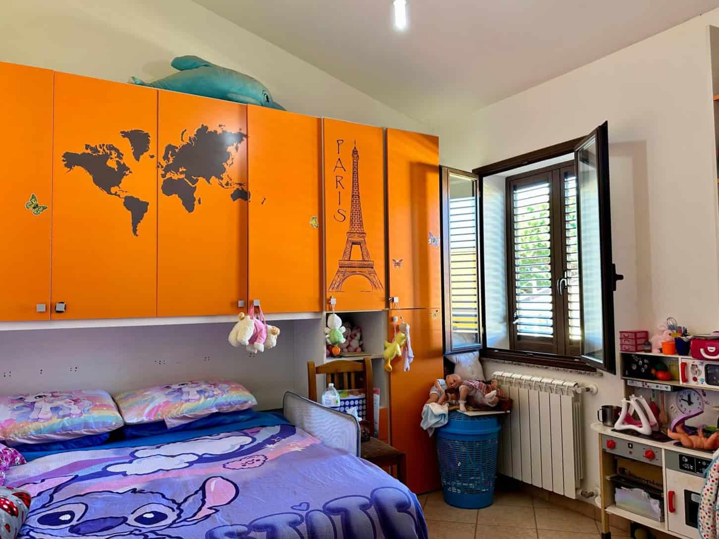 1. Armadio per bambini con decorazioni mondo e Torre Eiffel, spazio di gioco e riposo, in stanza da letto colorata.