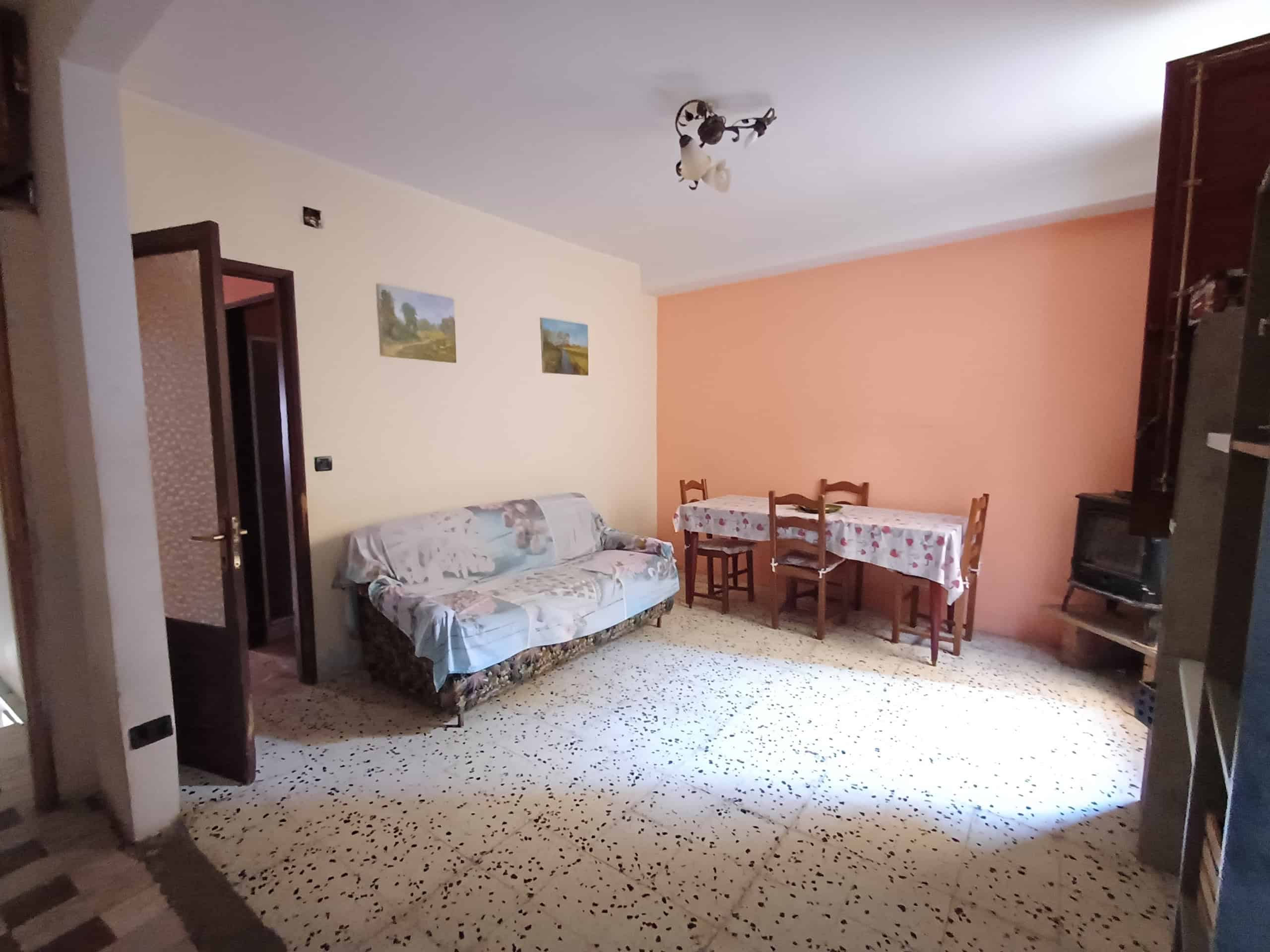 1. Appartamento accogliente con soggiorno e zona pranzo, arredi tradizionali, pareti colorate, perfetto per affitti turistici o residence.