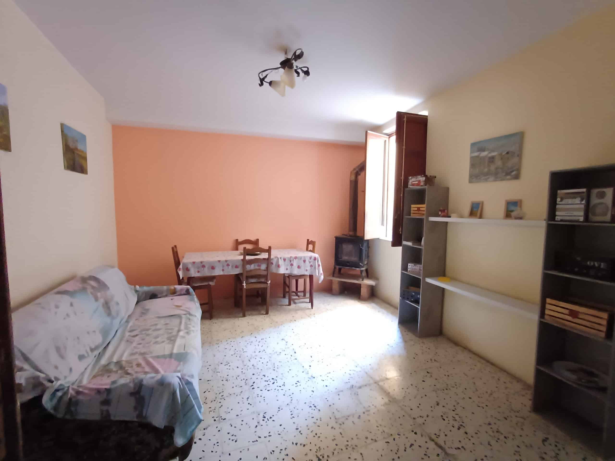 Soggiorno spazioso con divano, tavolo da pranzo, scaffali e camino, illuminato da finestra, ambiente luminoso e accogliente, ideale per vivere in comfort e stile.