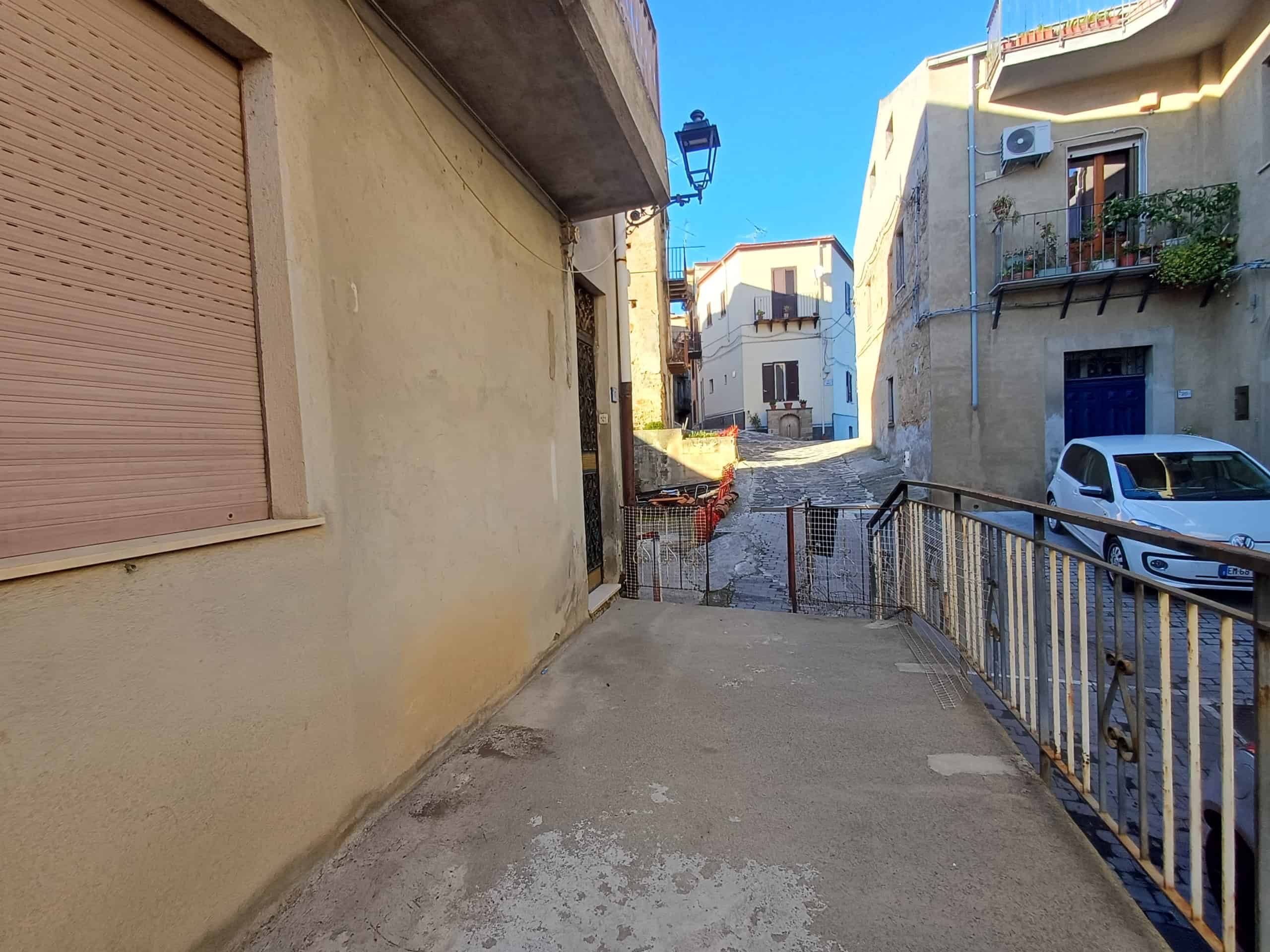 Vecchia via di montagna con case antiche e strada acciottolata, trasferimento impressionante attraverso i vicoli tradizionali, punto di vista suggestivo, tipico ambiente italiano.