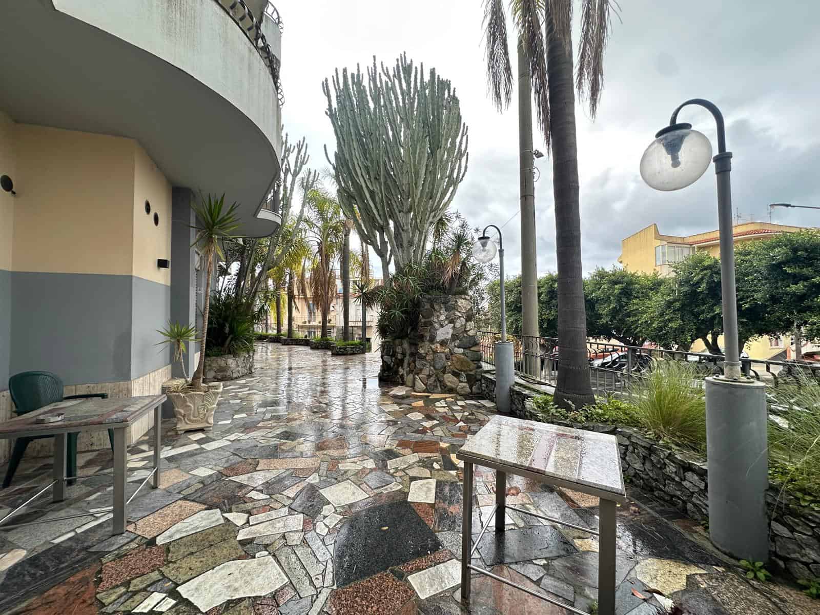 Verde urbano con piante esotiche e luci pubbliche in un esterno multicolore, ideale per immobili di lusso.