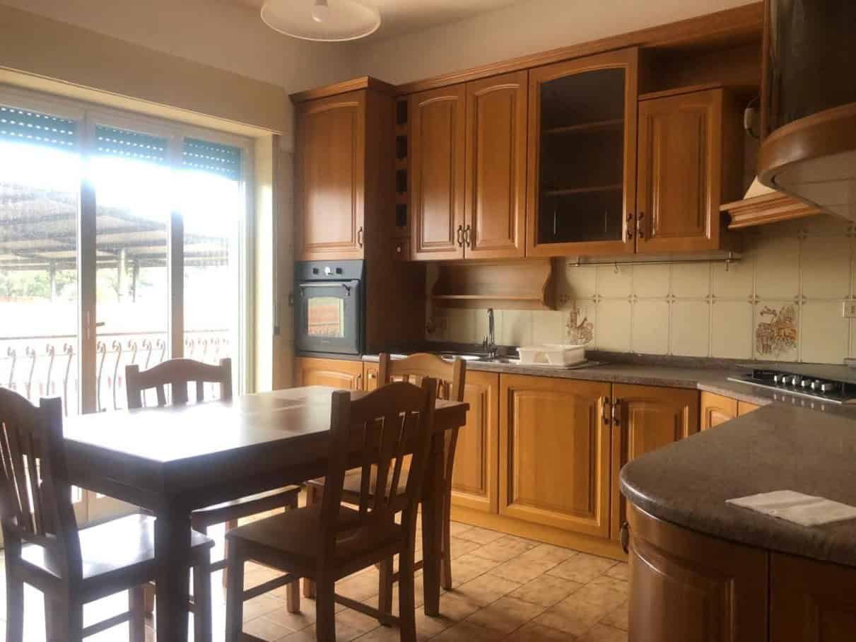1. Cucina abitabile con mobili in legno, forno integrato e piano cottura a gas, spaziosa e luminosa, ideale per famiglie e cene conviviali.