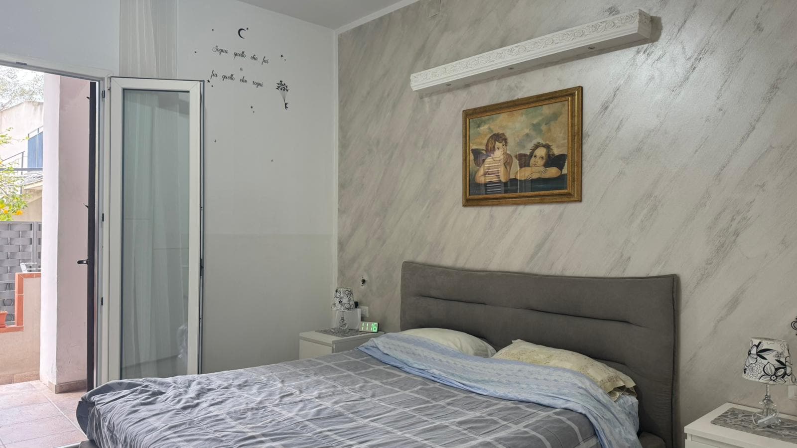 1. Letto matrimoniale moderno in camera con decorazioni eleganti e lampade da comodino, esposizione a terrazza o balcone, ambiente luminoso e accogliente.