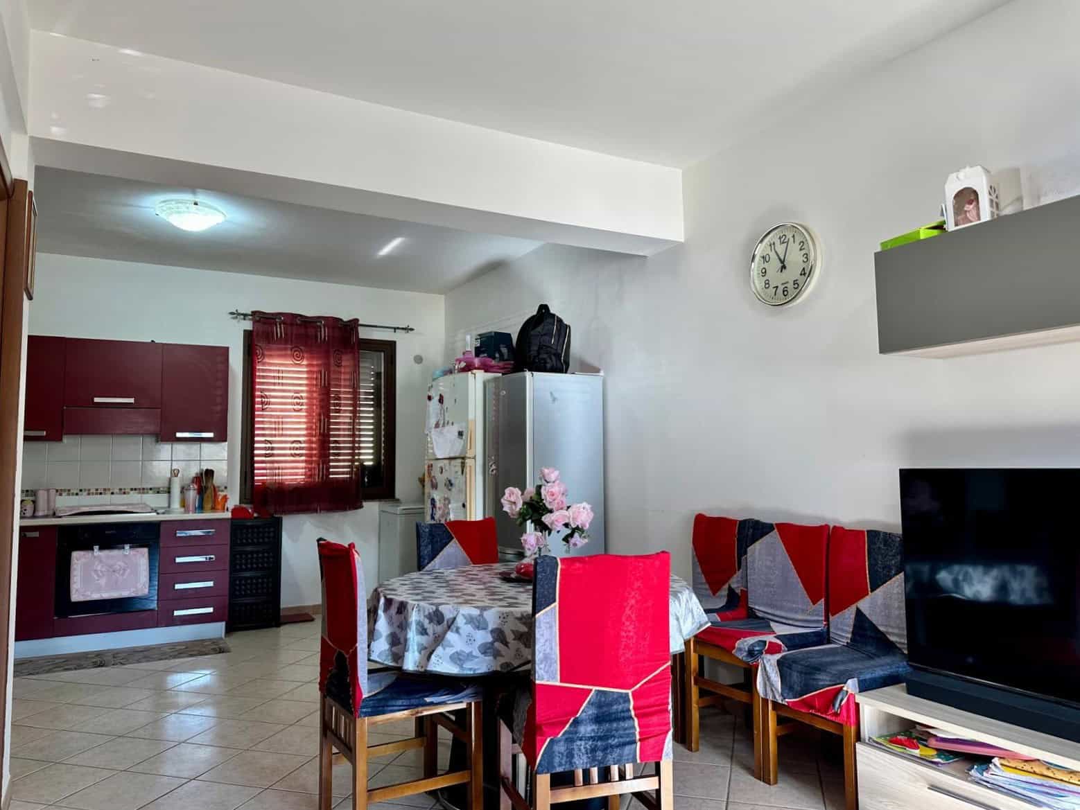 1. Appartamento in affitto a NextCasa con soggiorno e cucina open space, arredamento funzionale, zona pranzo con tavolo e sedie, TV e arredamenti pratici, ambiente luminoso e accogliente.