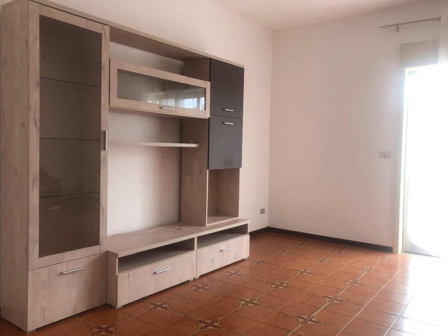 Armadio a parete in soggiorno con strutture in legno chiaro e dettagli in grigio scuro, ideale per arredare spazi moderni e funzionali.
