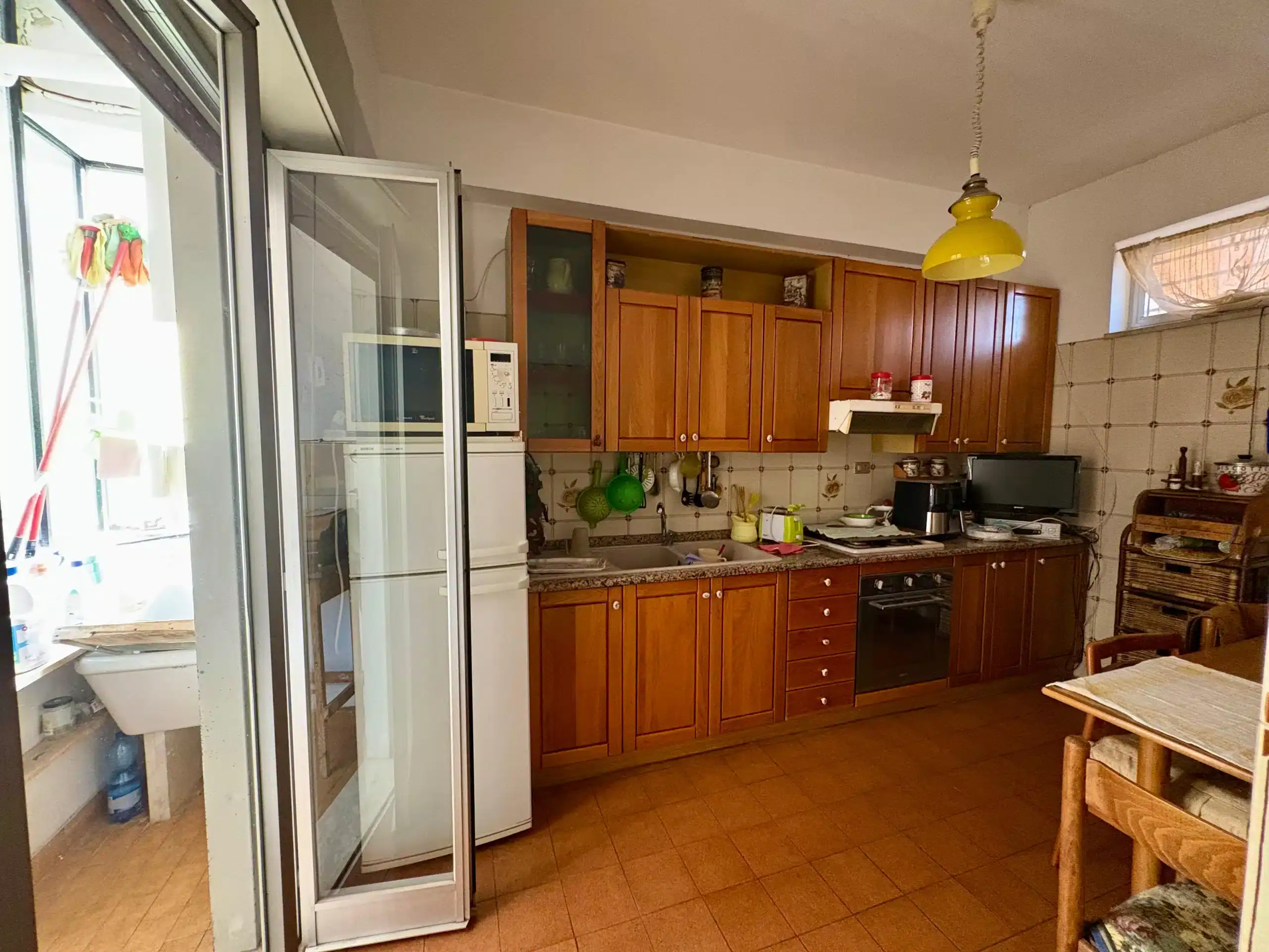 1. Cucina abitabile con mobili in legno, forno e frigorifero, ambiente caldo e accogliente in stile classico.