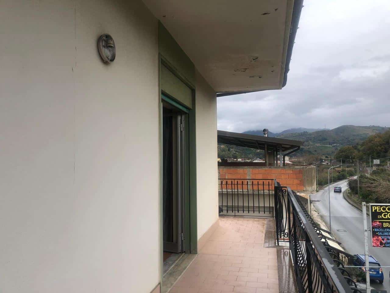 Vista dal balcone di un appartamento con vista panoramica sulle colline, strada sottostante e paesaggio urbano, ideale per immobili residenziali e investimenti immobiliari.