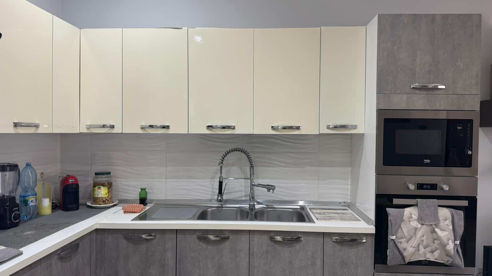 Lavastoviglie e forno in cucina moderna, pensata per comfort e stile, con armadi ante lucide bianche e dettagli eleganti, ideale per case moderne e funzionali.