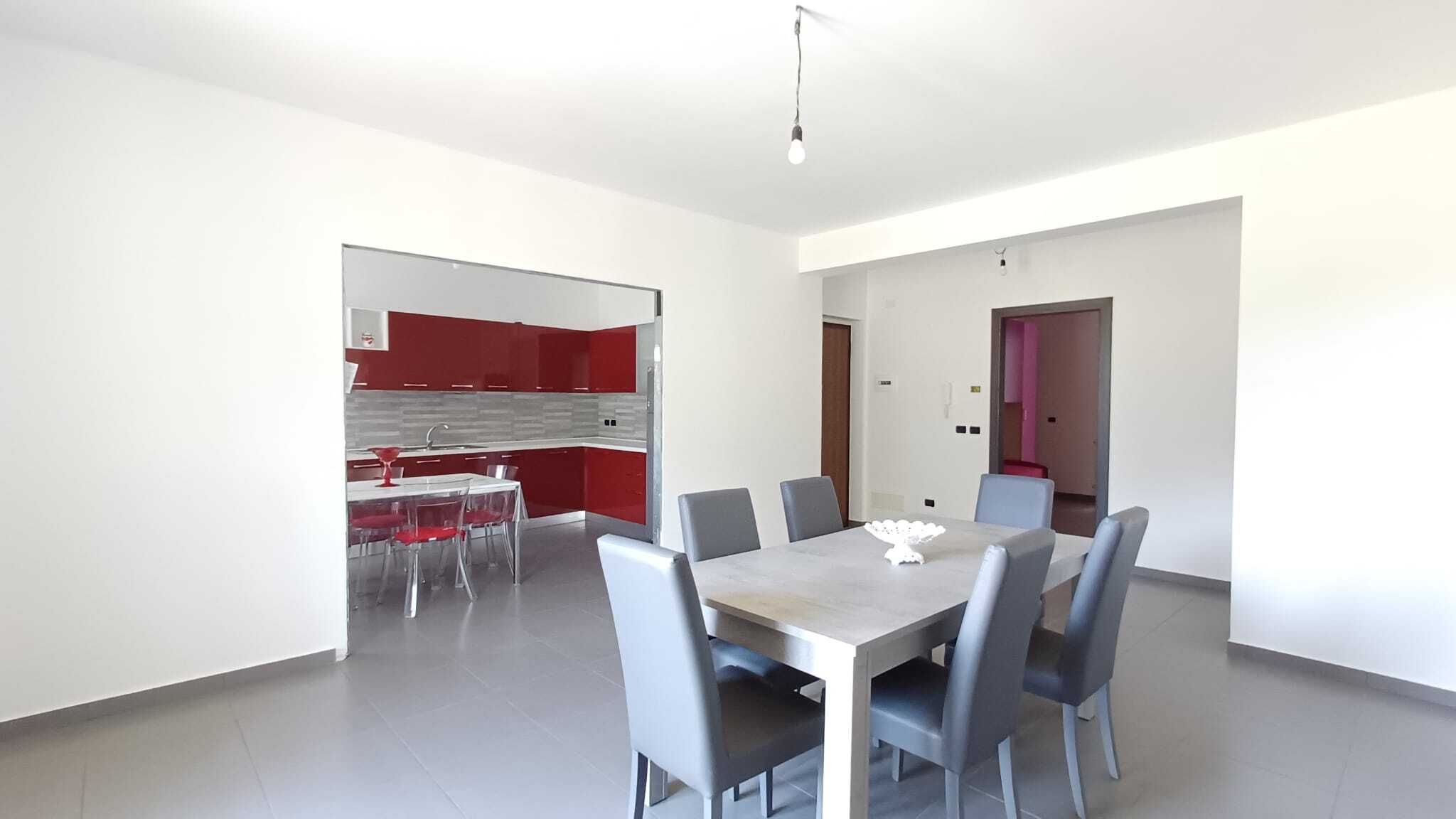 Elegante sala da pranzo con cucina moderna e arredi raffinati, ideale per vivere in stile contemporaneo.
