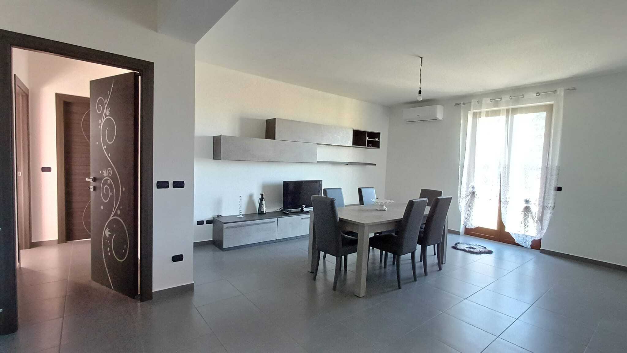Spazi di living moderni con arredamento minimalista, soggiorno luminoso e zona pranzo elegante, ideale per abitazioni di prestigio e case in vendita o affitto da NextCasa.